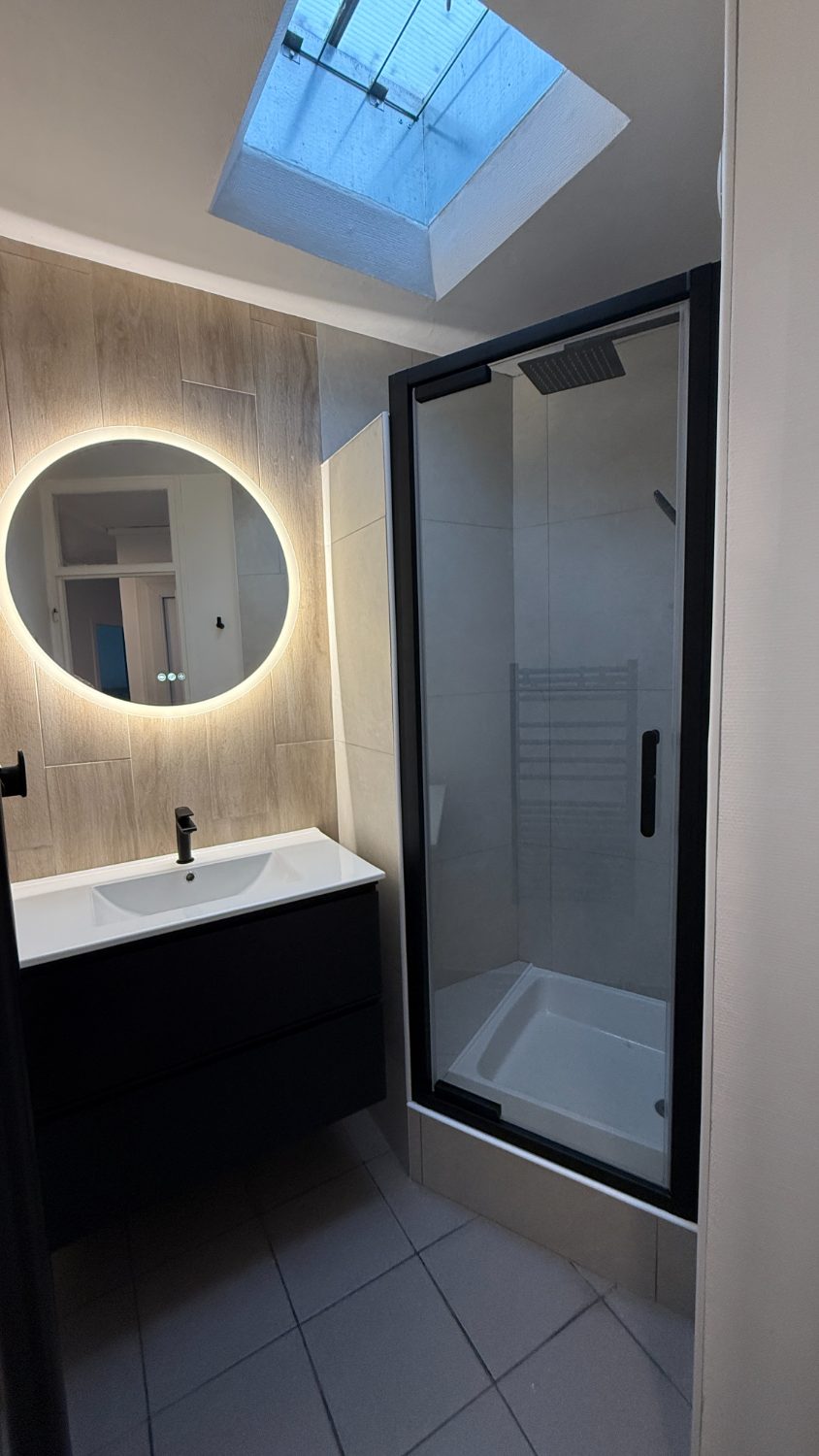 Douche paroi noire et miroir rond rétroéclairé
